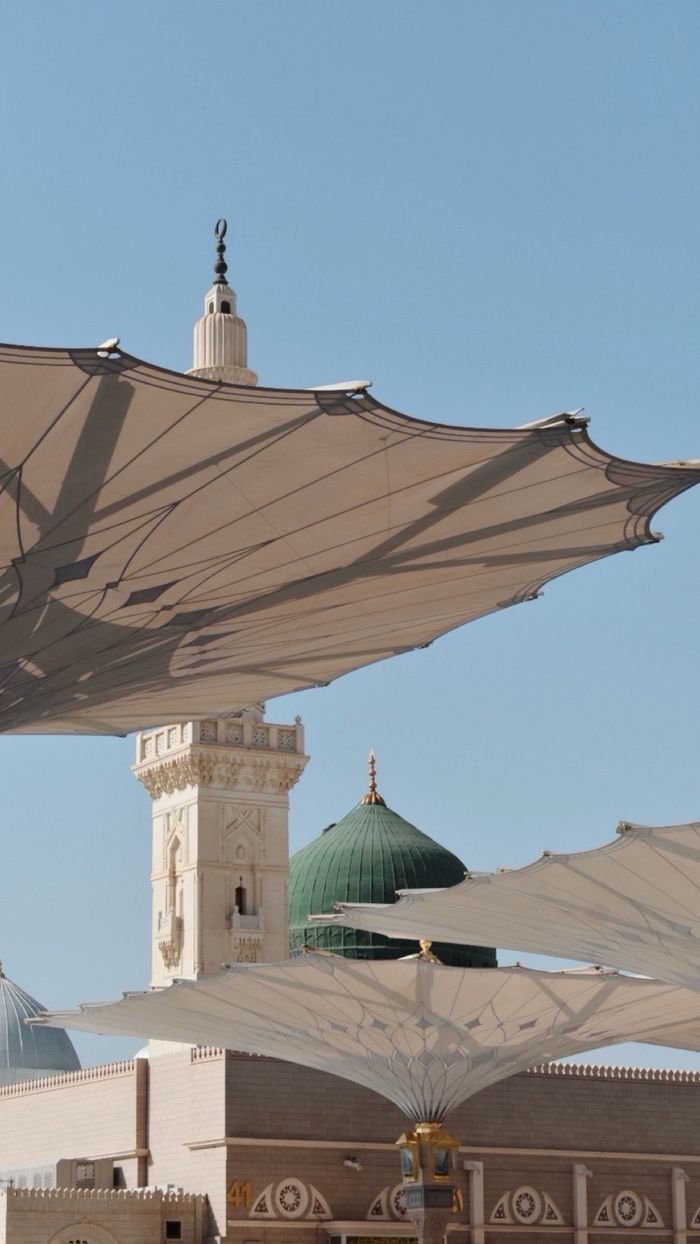 Scenic view of the Medina mosque with iconic umbrellas and skyline.